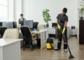 Two cleaners working in a modern office space.