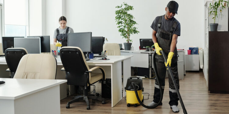 Two cleaners working in a modern office space.
