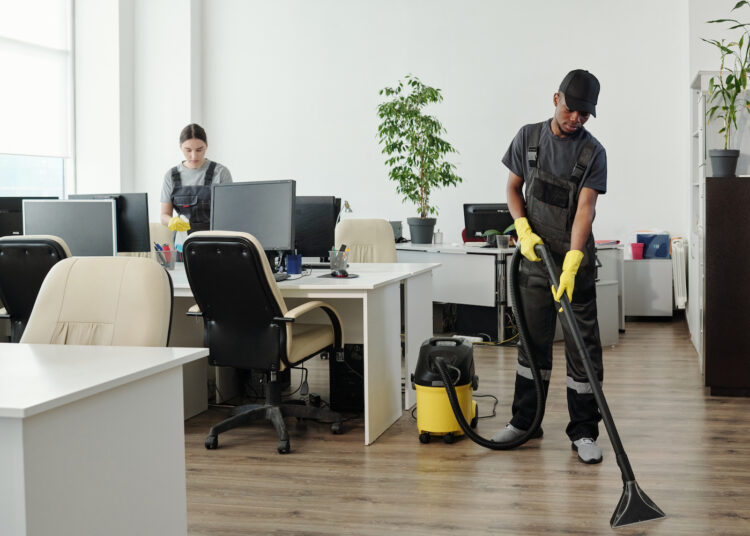 Two cleaners working in a modern office space.