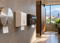 A Black African facilities buyer compares wall-mounted washroom dispensers.