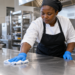 A food-safe stainless steel kitchen prep table being cleaned.
